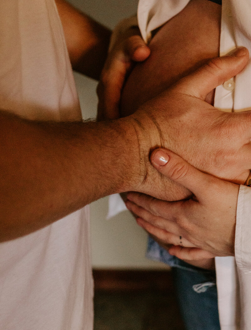 Oklahoma Pregnancy Announcement. Hands touching a pregnant belly