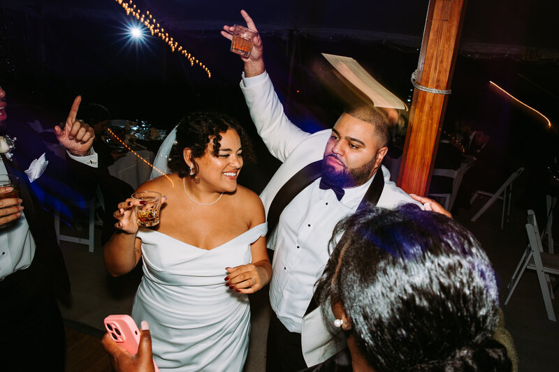 Bride and groom dancing at their wedding at The Hops Company in Connecticut holding signature drinks