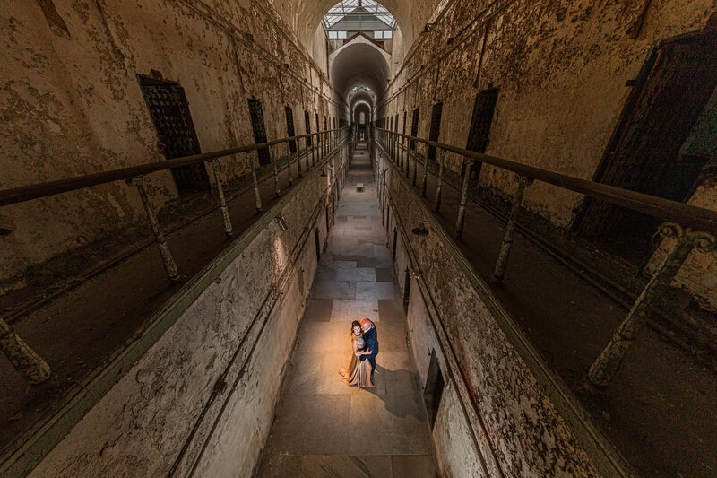 A hauntingly beautiful engagement session in the famous hallway of Eastern State Penitentiary, featuring a dramatic and eerie atmosphere.