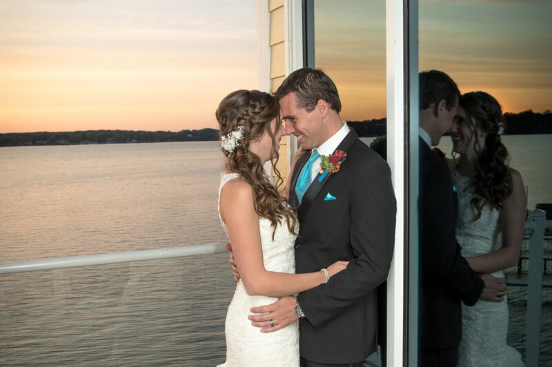 Bride and groom embrace on the water on their wedding day