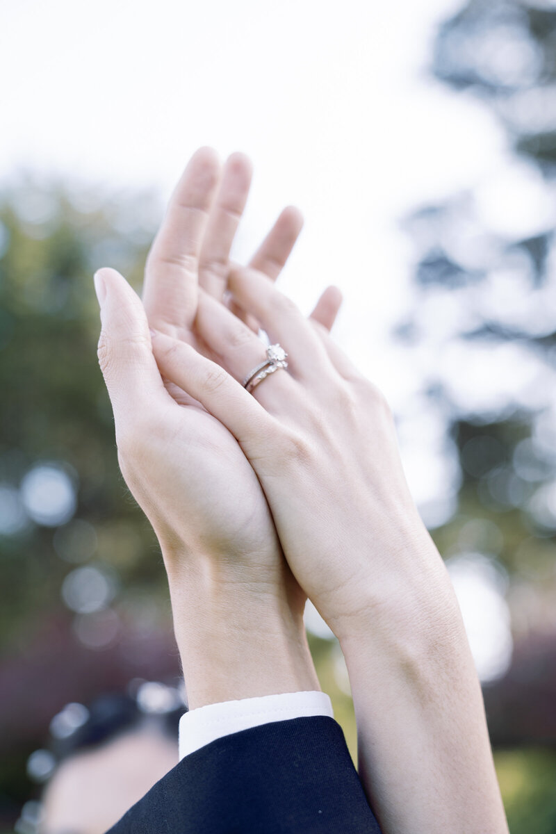 Holding hands and showing off the wedding rings at an elopement at golden gate park, San Francisco Califonia