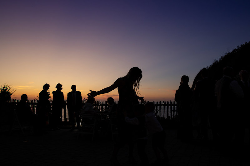 Guest dancing outside at sunset at Tunnels Beaches Devon
