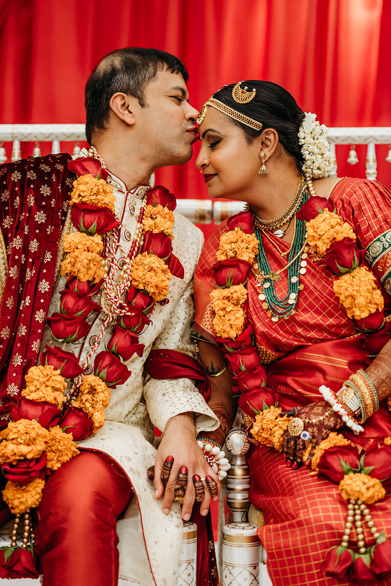 Groom kisses his bride's forehead