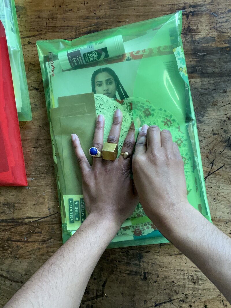 Image of Michaela's hands sealing a collage kit for a participant