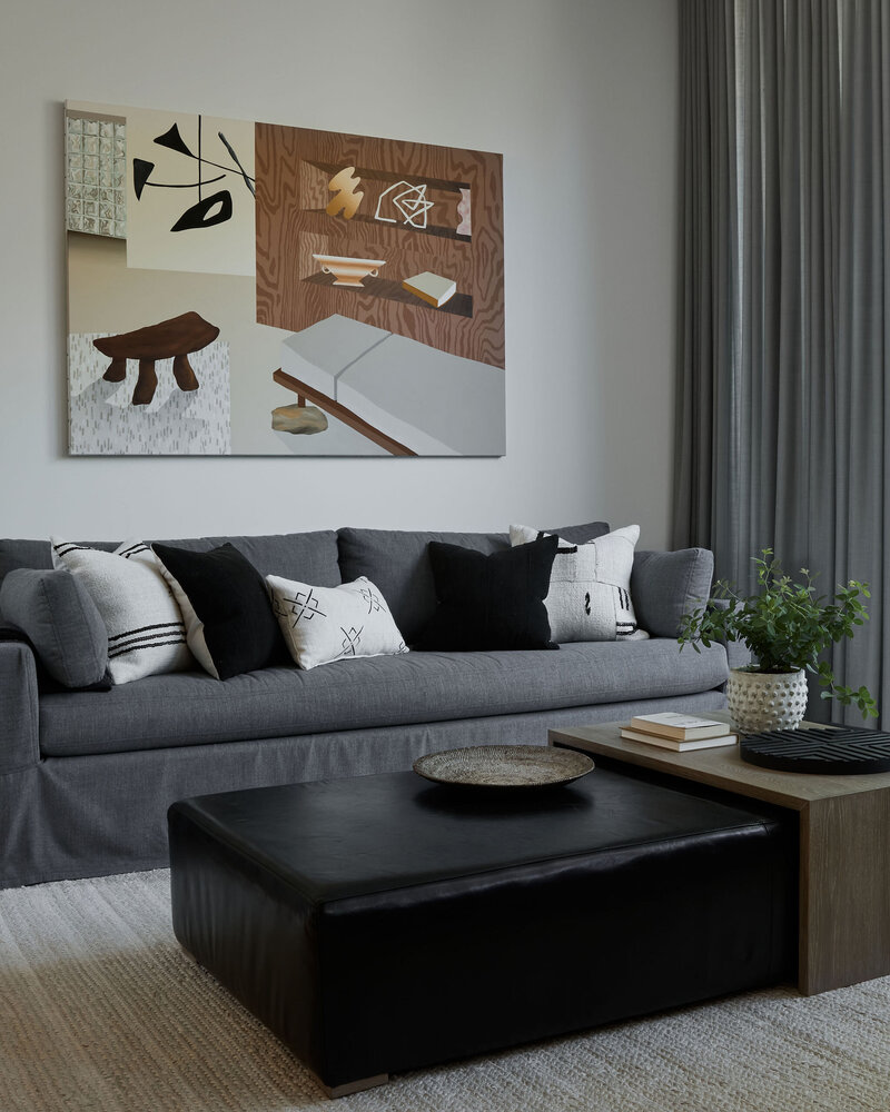 Contemporary art piece hung above a slate colored sofa