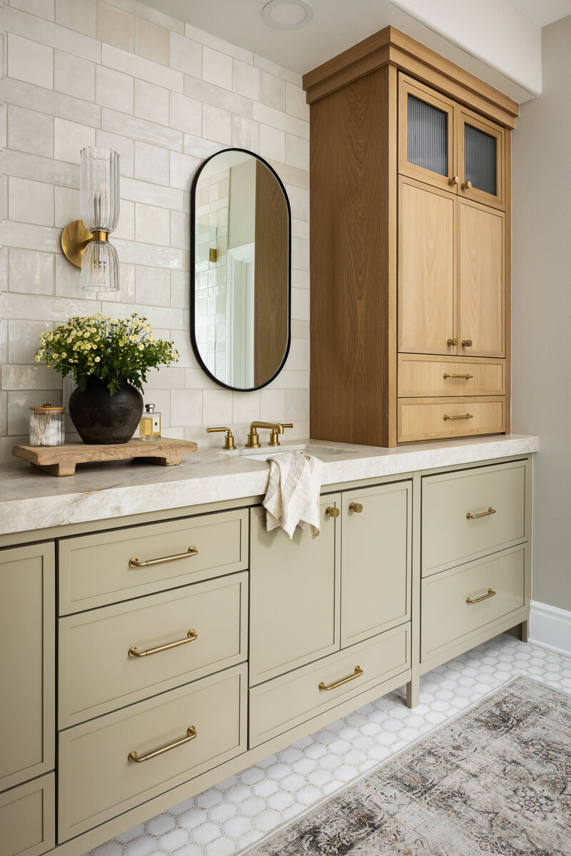 painted cabinets with quartzite countertops, ceramic tile backsplash and wall sconces with brass plumbing