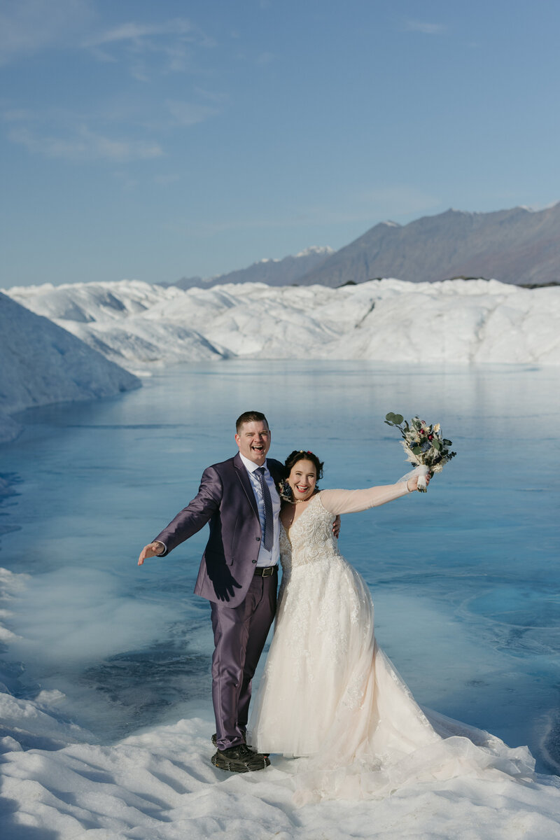 A couple standing on a glacier in Alaska