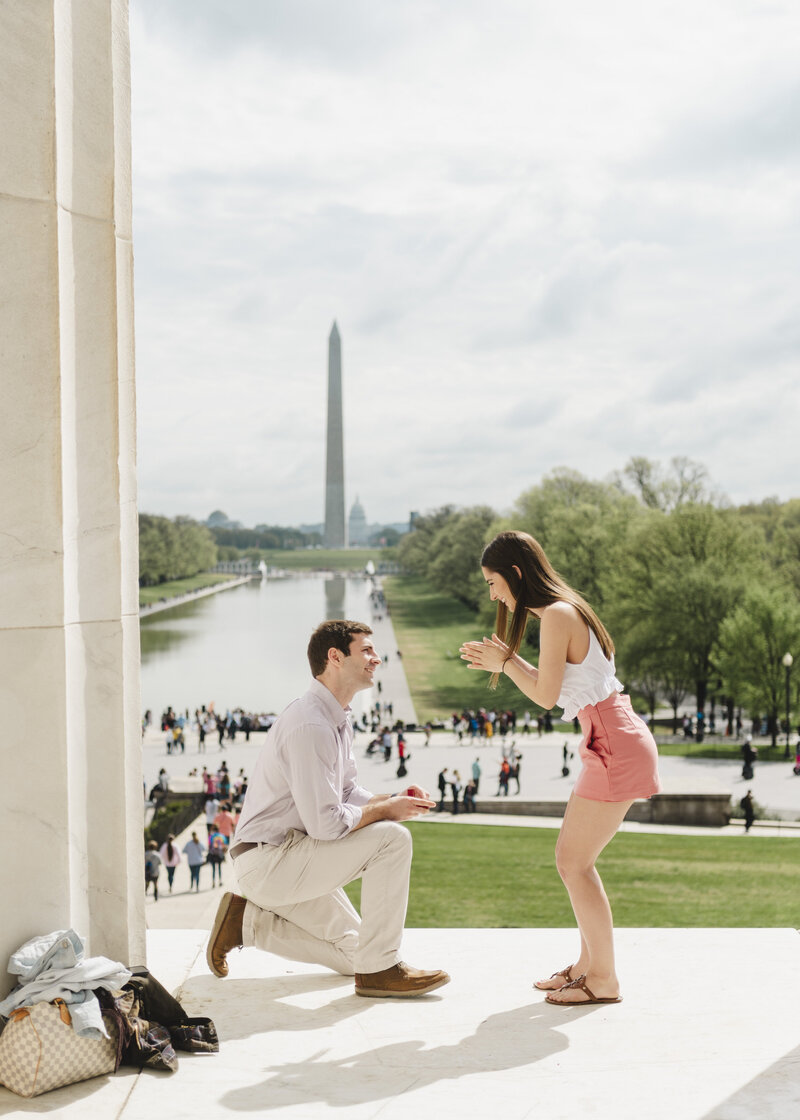 A person kneeling down and proposing to their partner at the Lincoln Memorial 