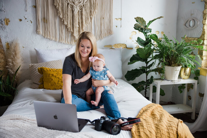 Photographer Christina Barnett holding baby while working