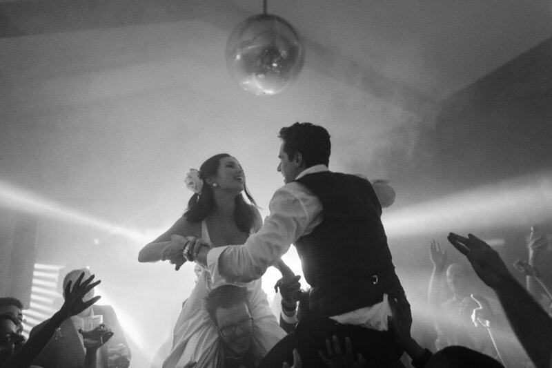 A couple enjoying their wedding party at Pazo de Treilán, Galicia, dancing on the shoulders of their friends. 