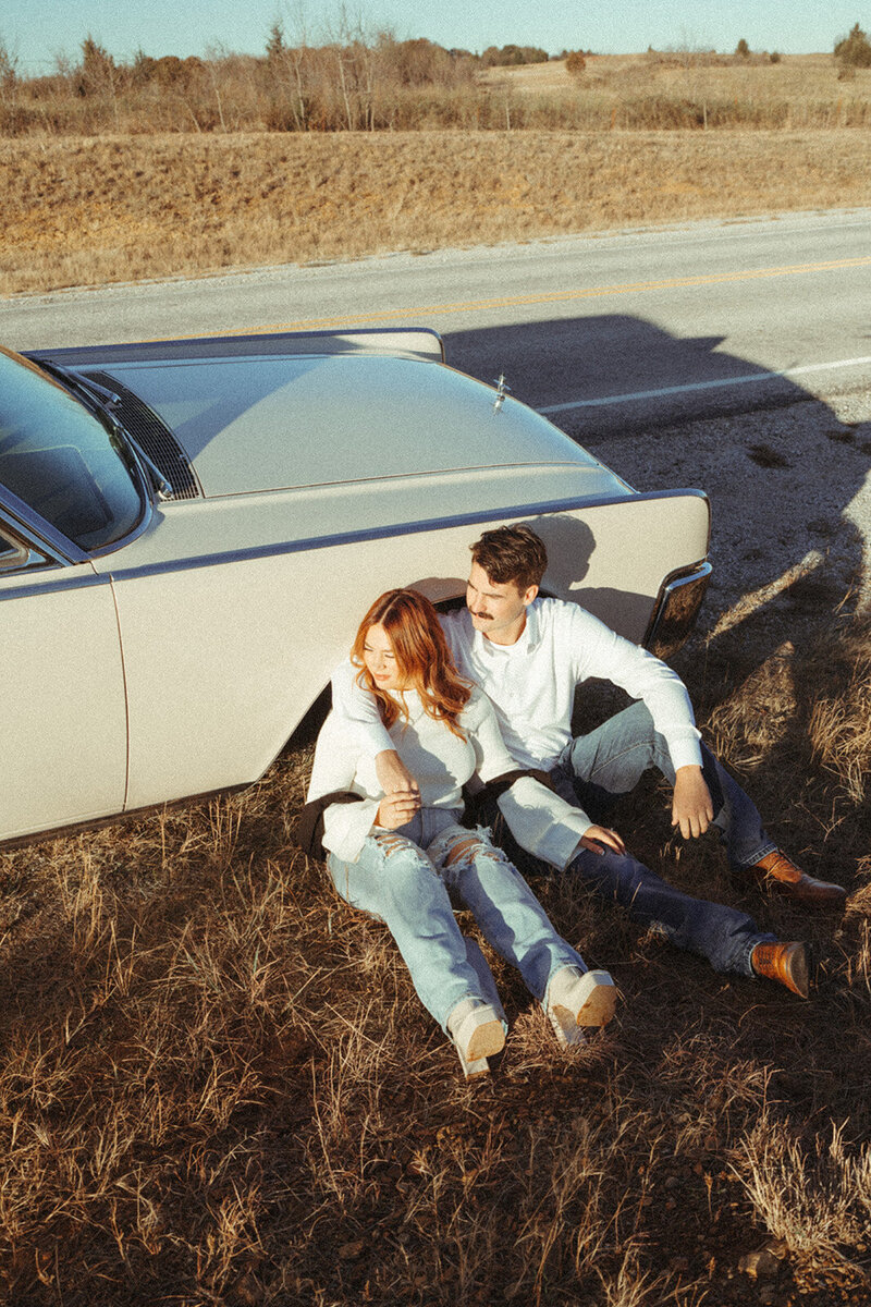 Couple sitting by the rode by a car