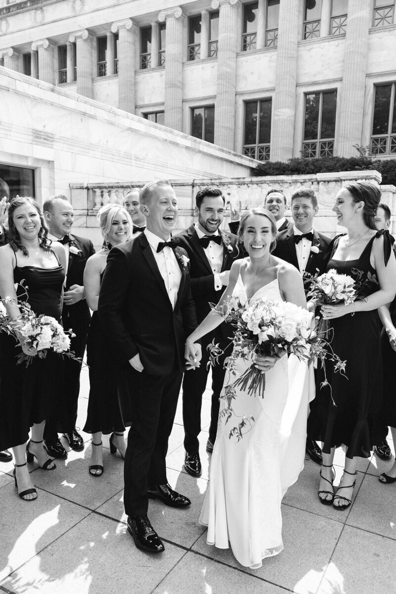 Wedding party celebrating outdoors with the bride and groom in the center