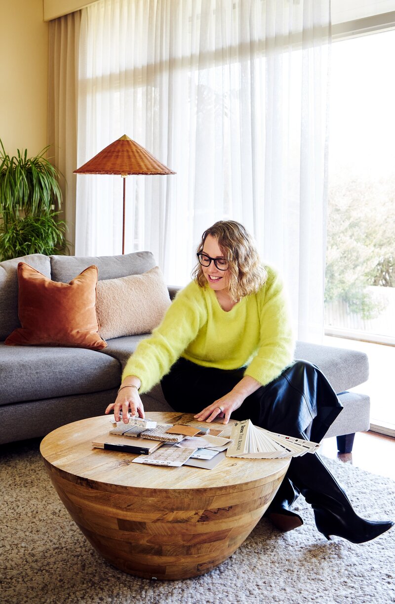 Interior designer in bright jumper holding samples