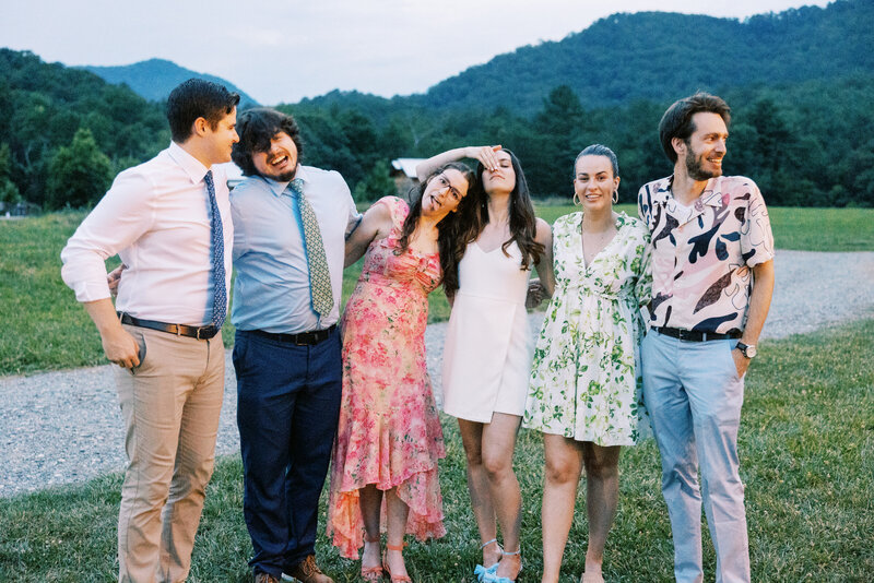 The bride with a wedding dress change hugs her friends at the scenic venue in North Carolina Paint Rock Farm, by film photographer My Sun and Stars Co.