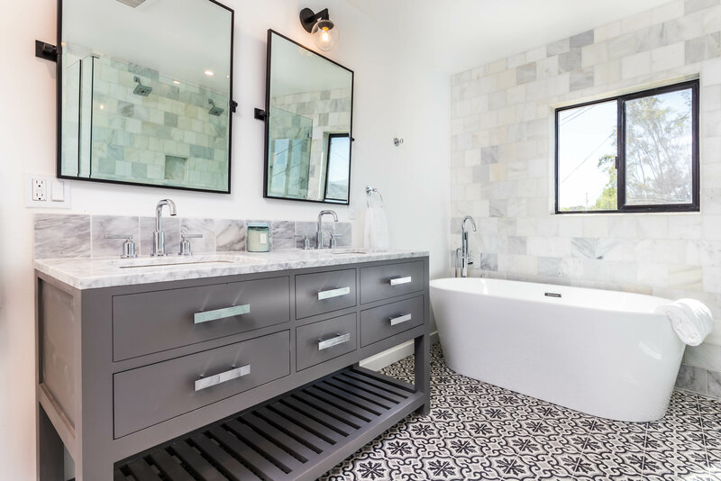 modern and sleek bathroom design with free standing tub and charcoal gray vanity and unique mosaic floor tile. 