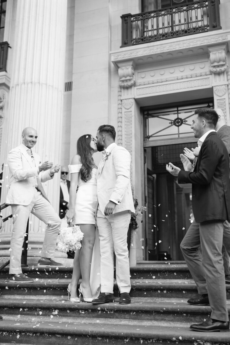 bride and groom kissing outside town hall