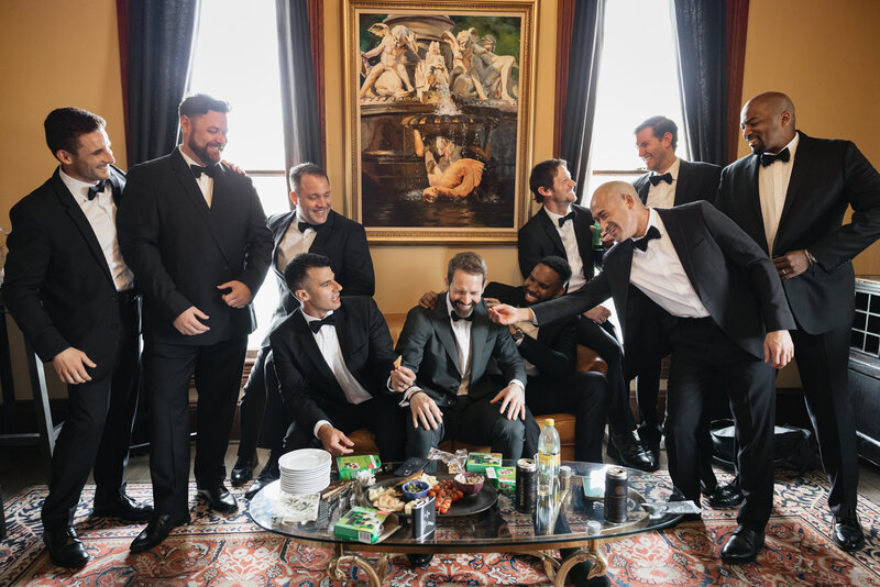 groom and groomsmen pose for photographer at bar mansion wedding venue