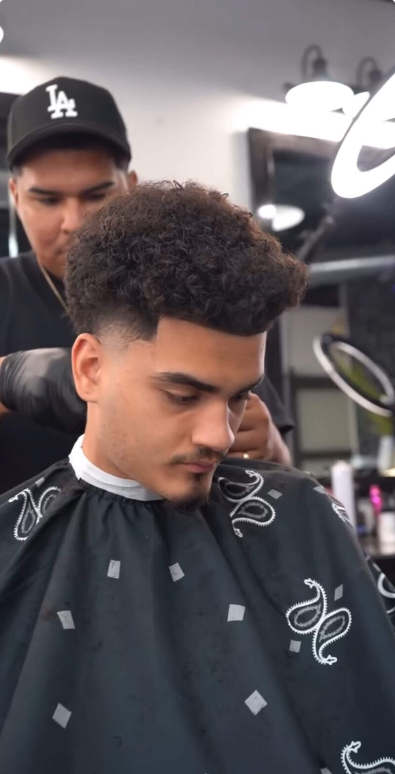 A barber cutting a fade haircut with a great blend at Onyx Barbershop in Wildomar, CA.