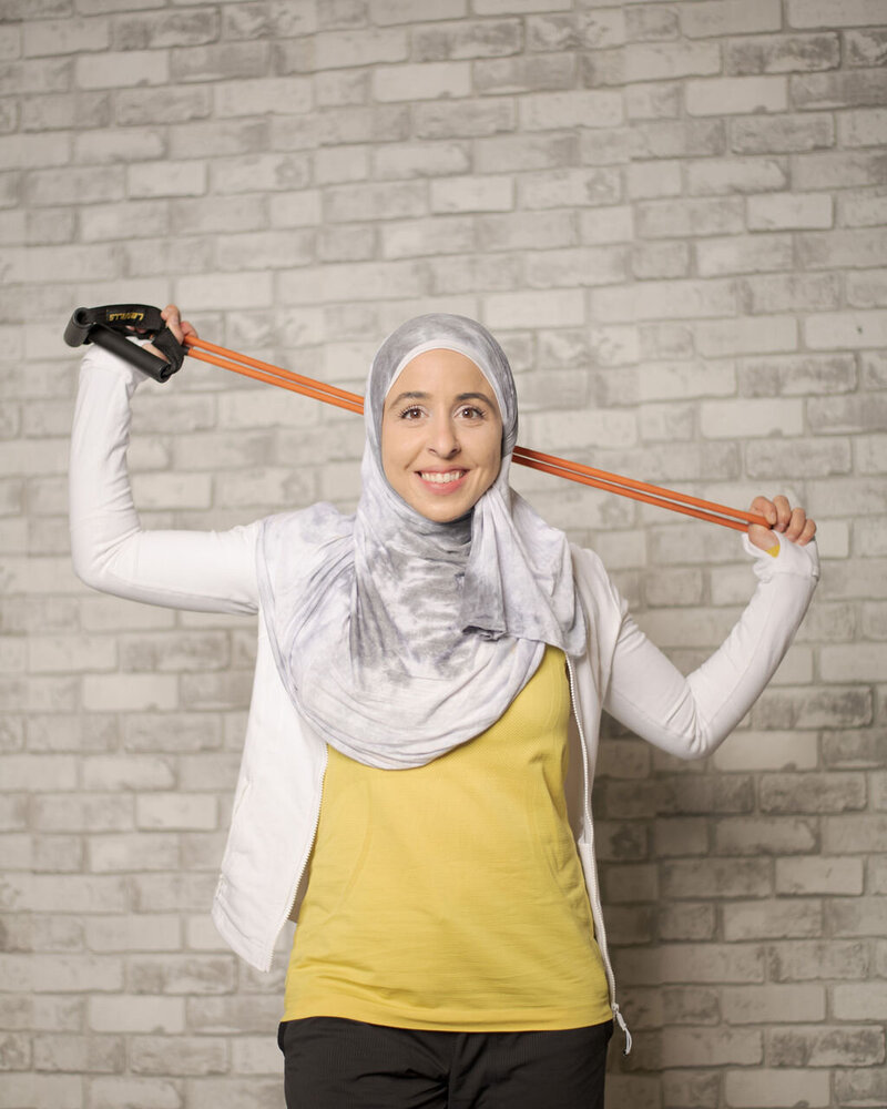 Fitness hijabi coach Hanan posing with a smile and fitness gear