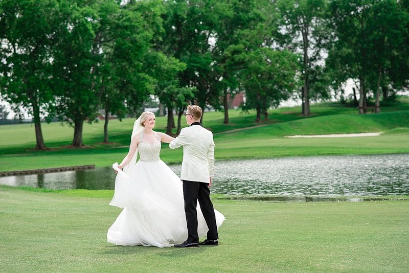 Bride and groom dancing together at a pond at Stones River Country Club