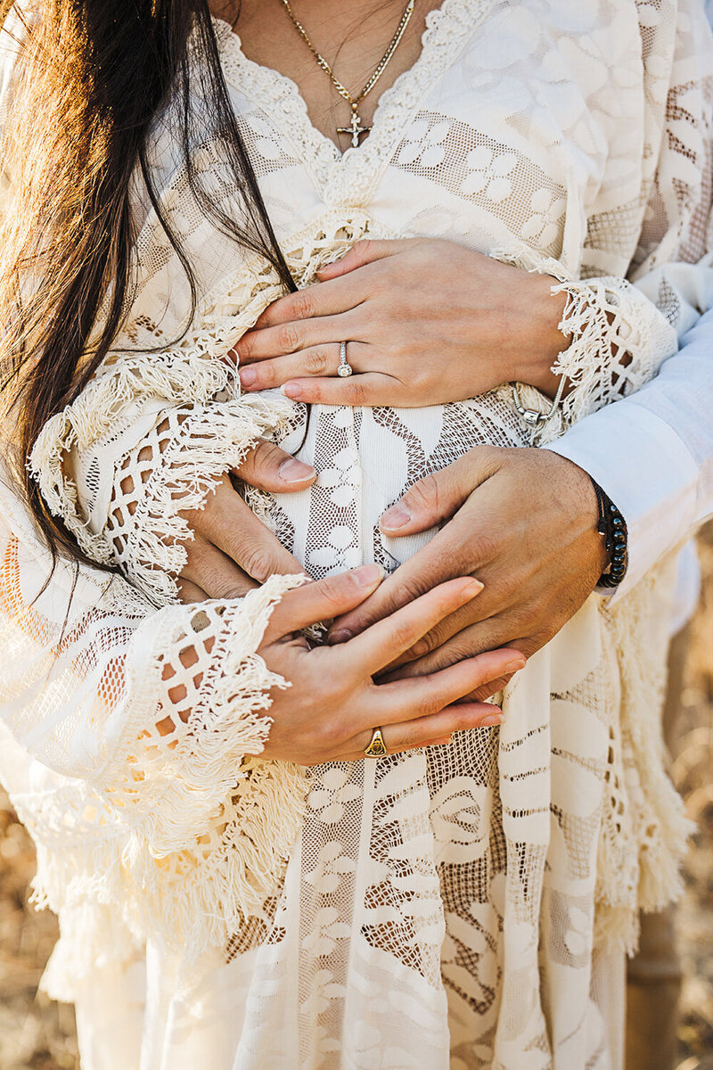 boho maternity dress with hands on mothers bump