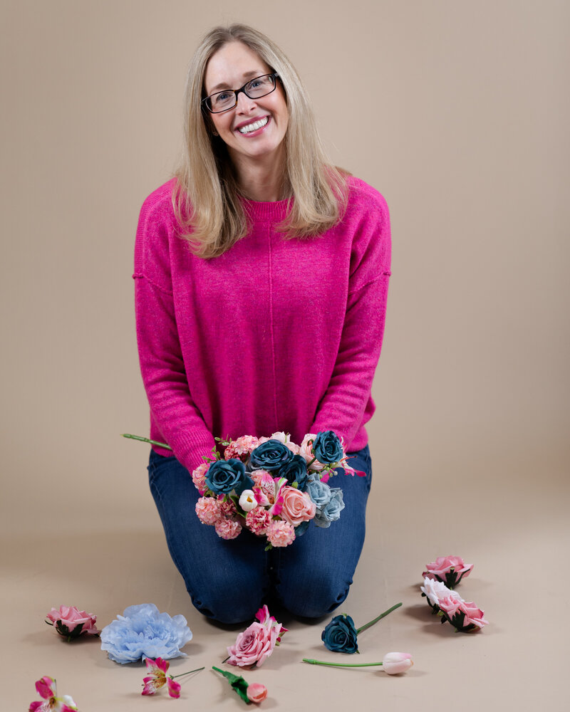 Holding a pink and blue floral bouquet