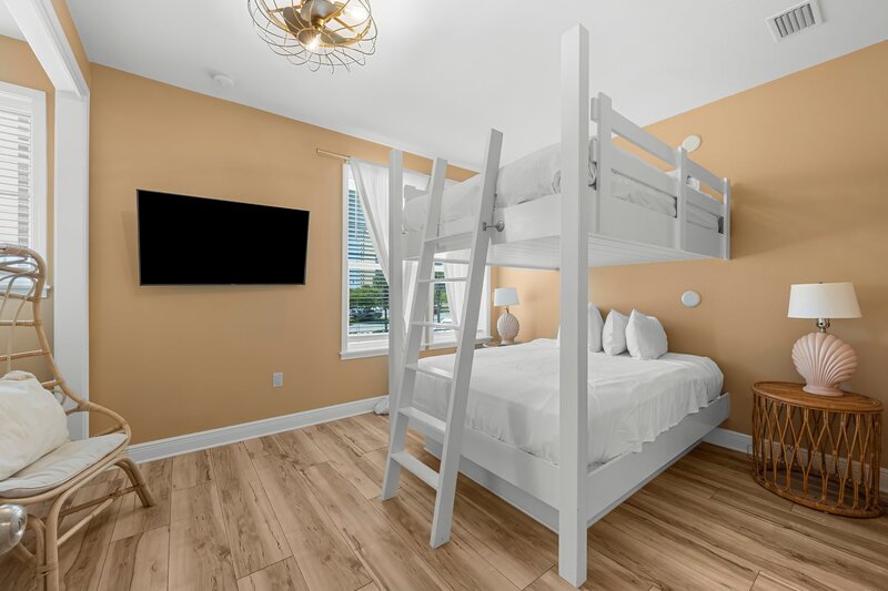 Charming upstairs bunk bedroom with queen beds and smart TV at Beach Cabana, ideal for groups visiting Panama City Beach, 30A, and Santa Rosa Beach.