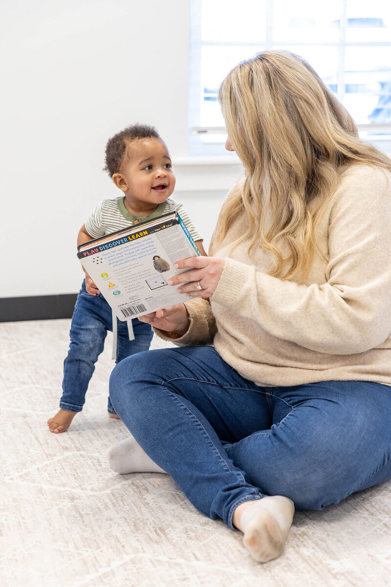 Woman showing a book to a baby