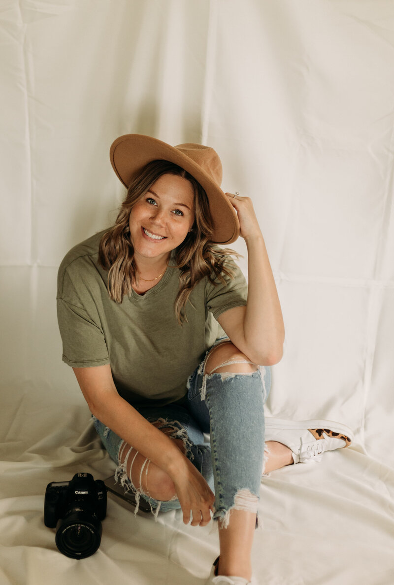 Photographer Heather Sue sitting in a white studio.