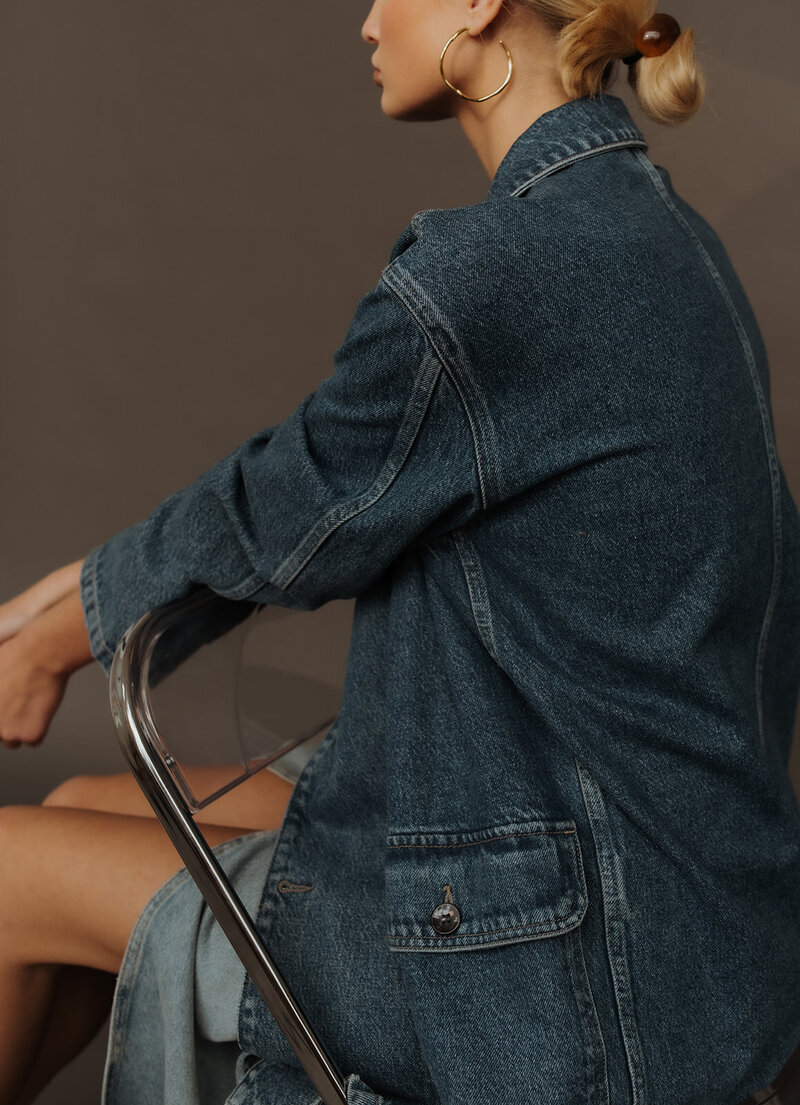 woman sitting on a chair in a denim jacket