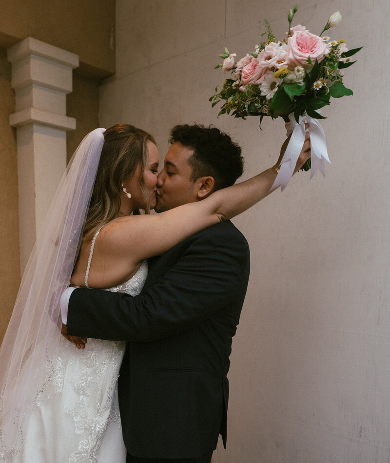 The bride and groom are kissing