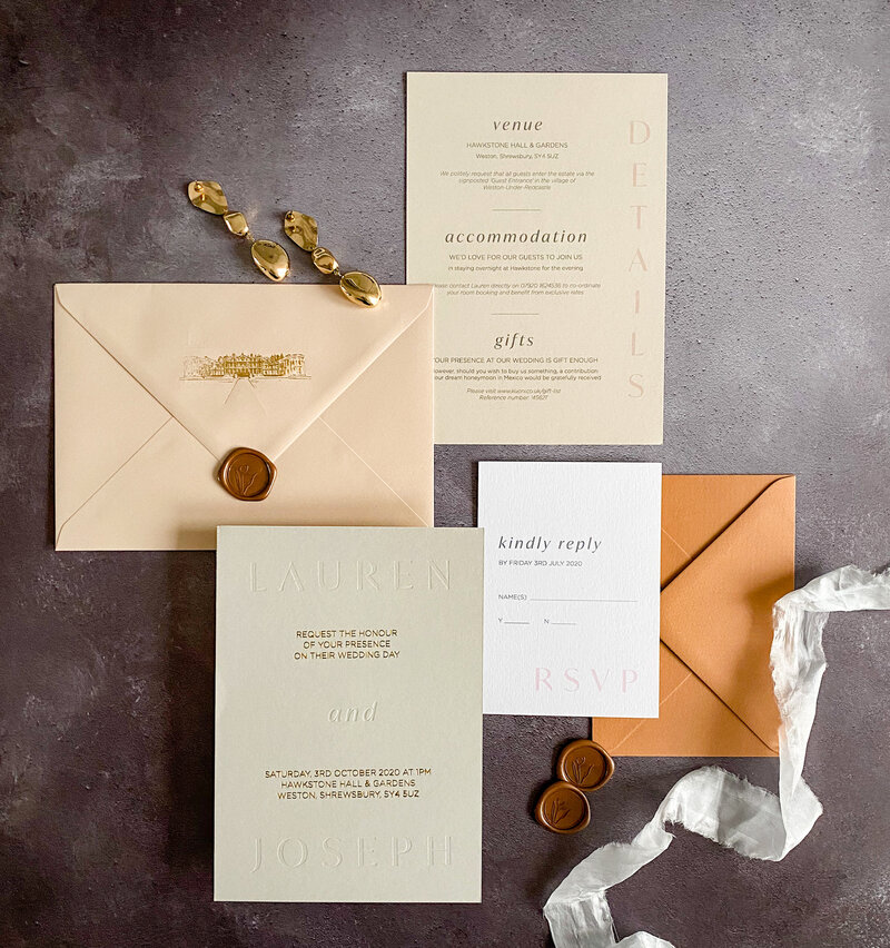 Flat lay of foiled and letter press wedding stationery suite