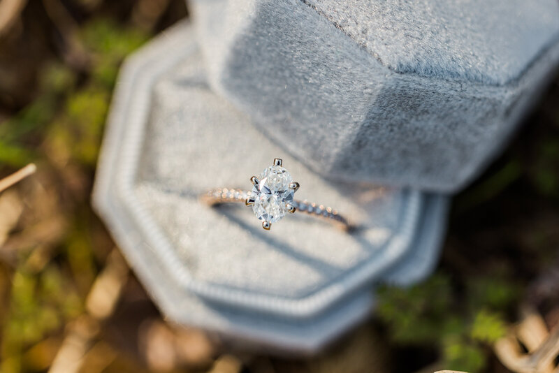 Close-up of diamond engagement ring and wedding band on a soft velvet surface, reflecting natural light.
