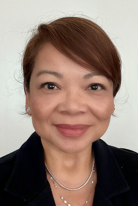 Headshot of Lorena Gatdula. She is a brunette, with swooped bangs, wearing a black blazer.