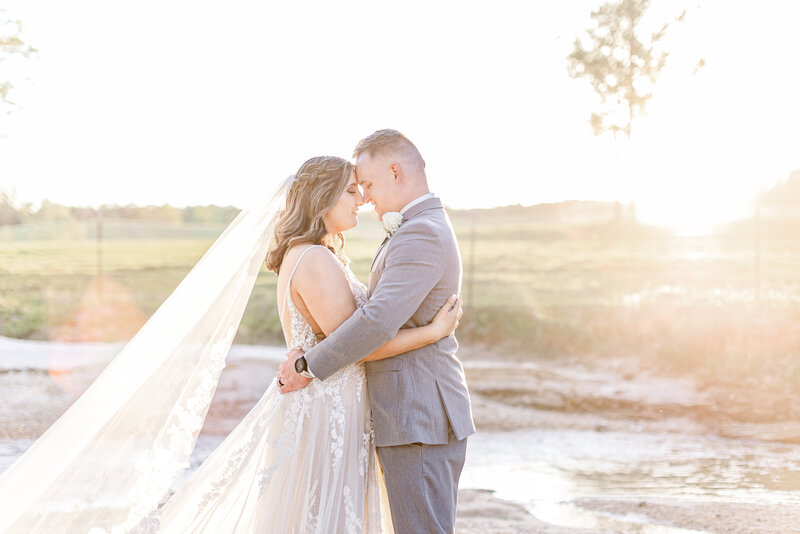 Couple embracing in warm sunlight at wedding at the Hideaway at Reeds Estates in Brookhaven, MS.
