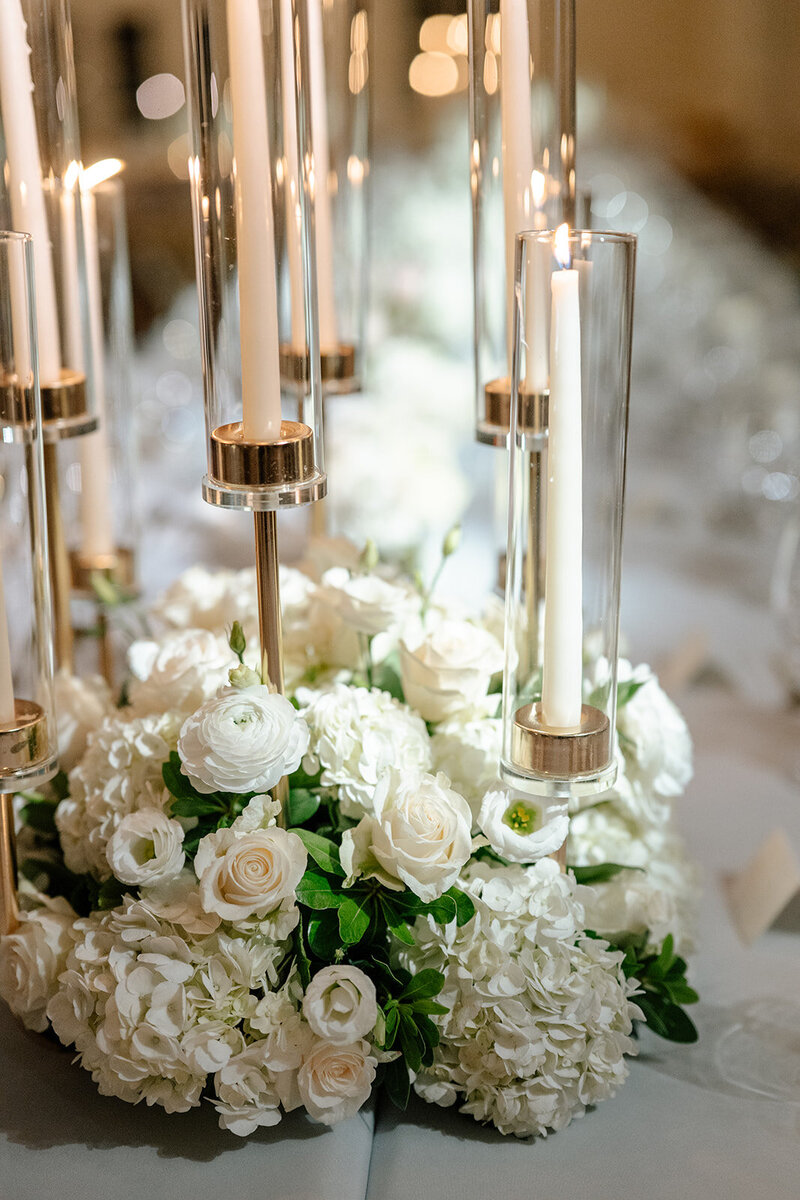 White roses and taper candles on a reception table