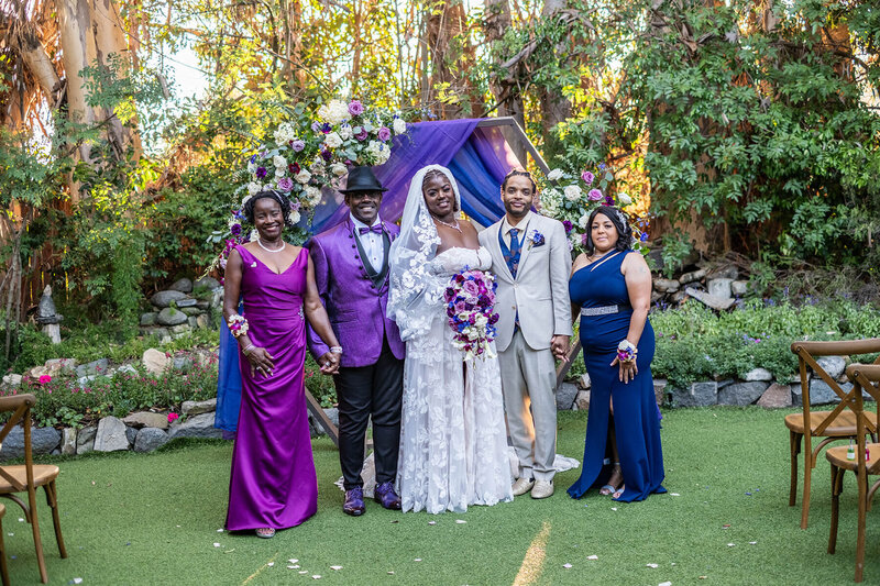 Bride and groom posing with family members at The Twin Oaks venue, photographed during scheduled family portraits in the First Look wedding timeline.