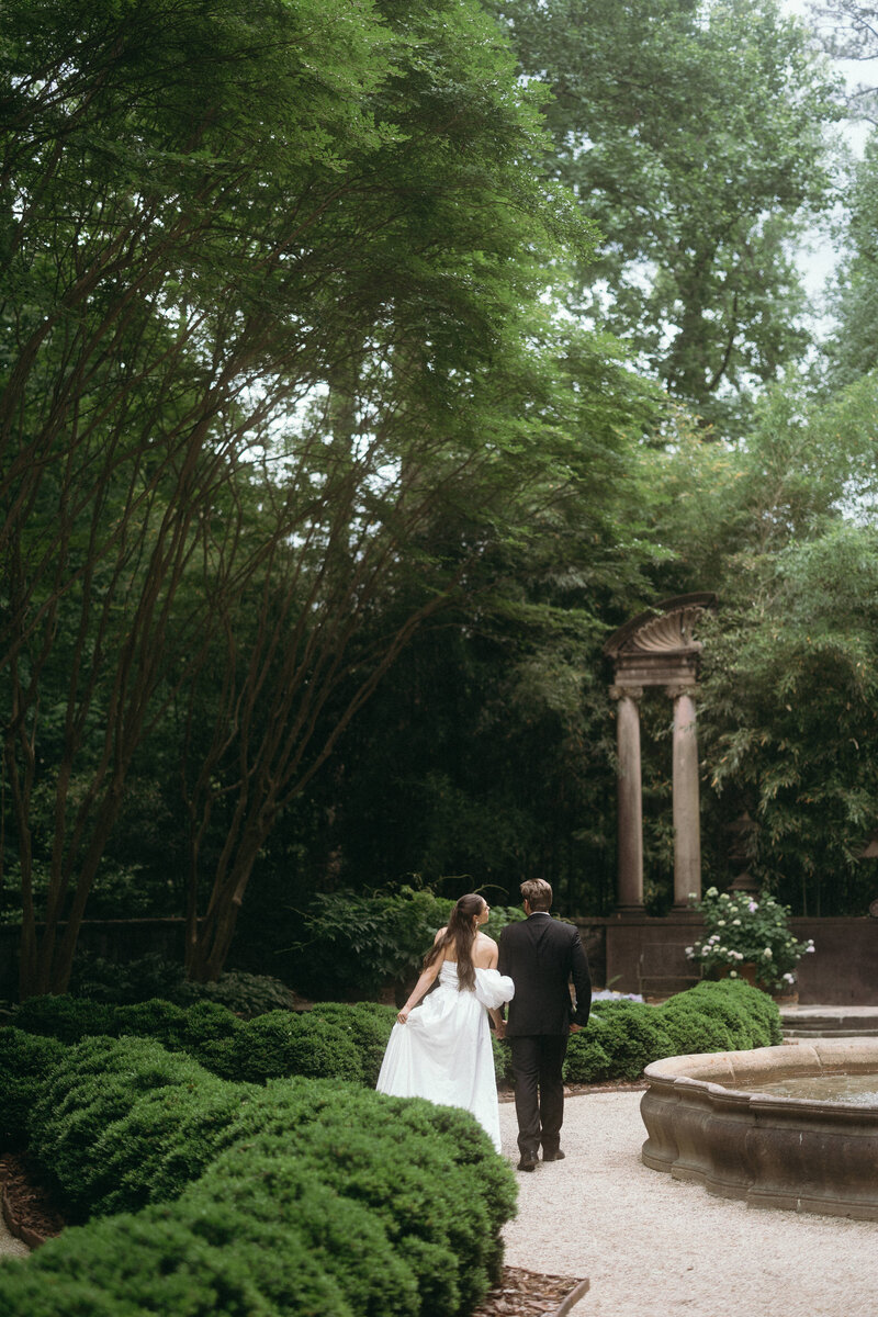 Groom lovingly walking with bride in a garden during their North Georgia wedding, surrounded by a peaceful and intimate setting.
