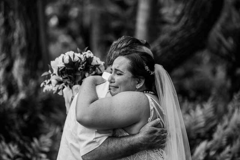 Black and white photo of bride and father hugging