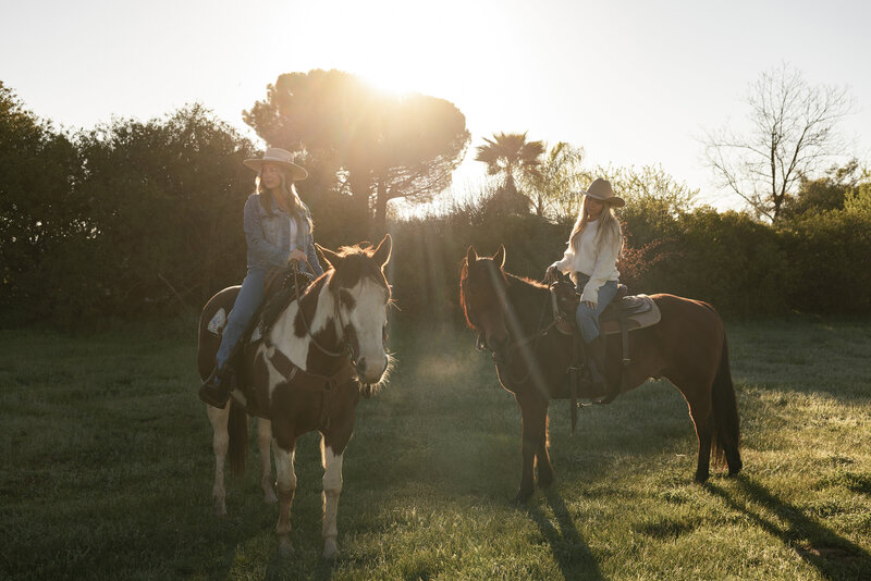 Two women riding horses at sunset in a stylish Western branding shoot — photographed by Dani Lacey Photographs in Greenville SC.