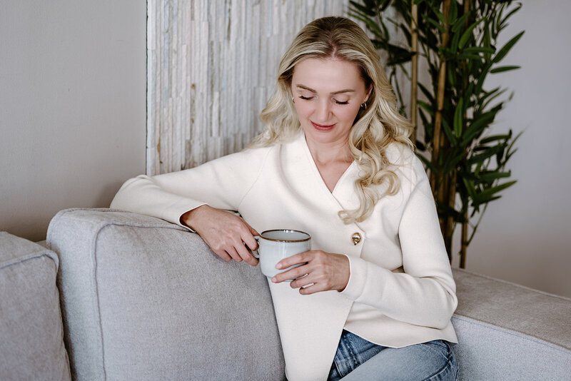 Female wellness coach on the sofa with a coffee