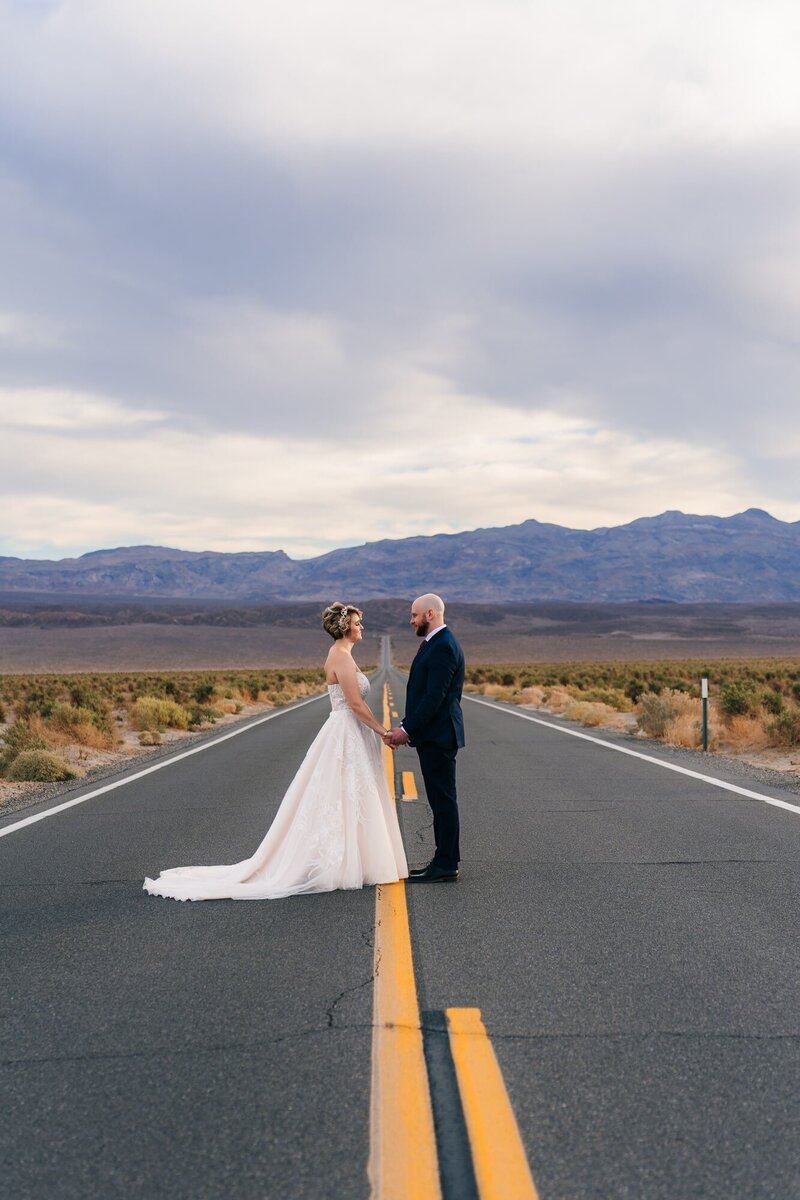 Beautiful couple standing at the middle of the road at Devil's Cornfield in Death Valley.