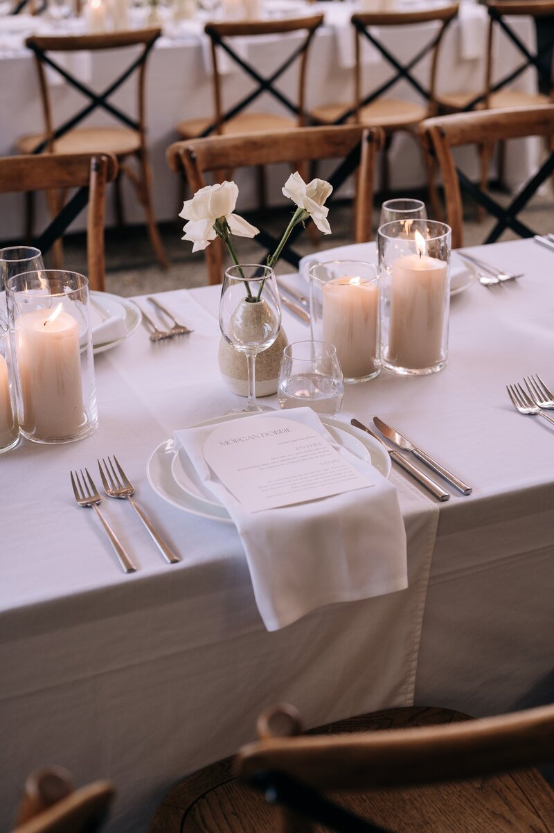 beige candles and white decor on the tables with wooden chairs at the winehouse in queenstown