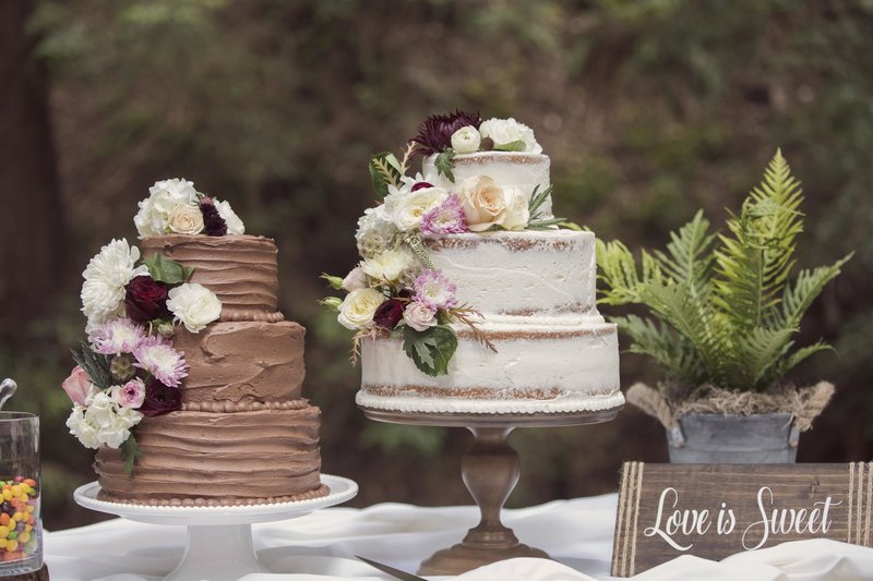 Chocolate and Vanilla wedding cakes with florals at wedding on private property near Watsonville