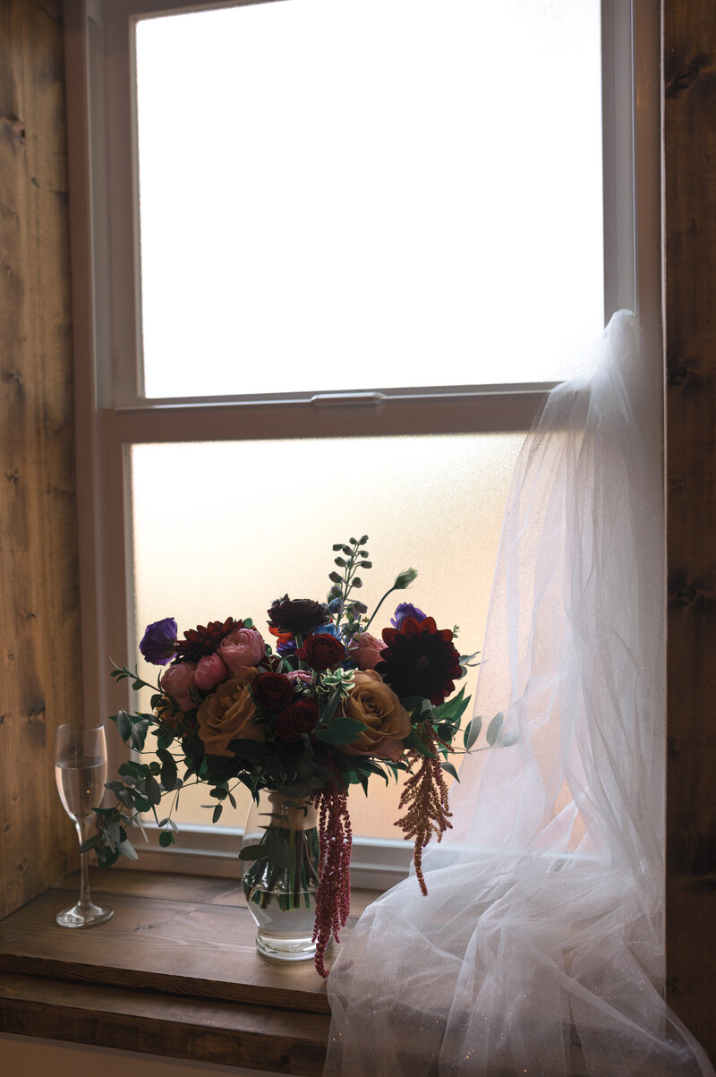 bouquet veil and champagne details shots by a window