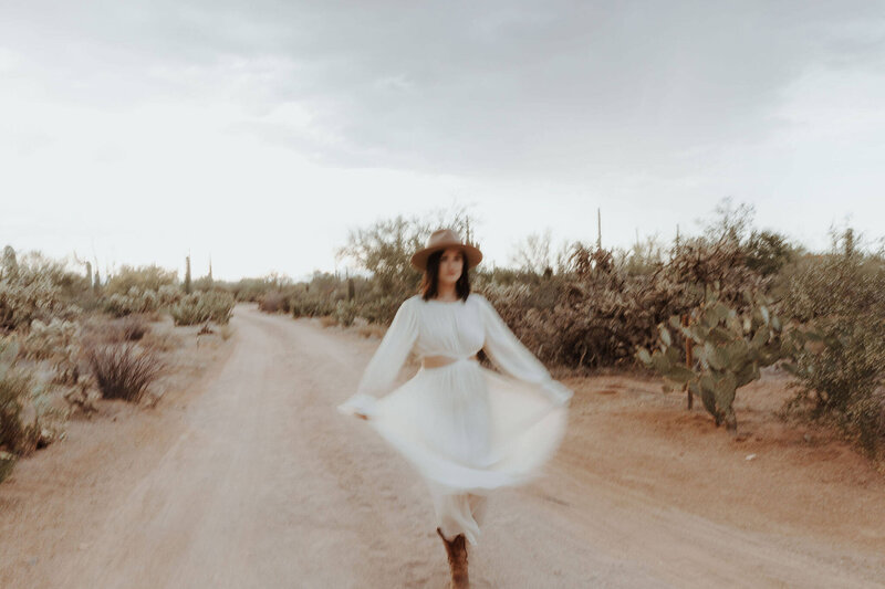 the girl in a white dress posing in the desert
