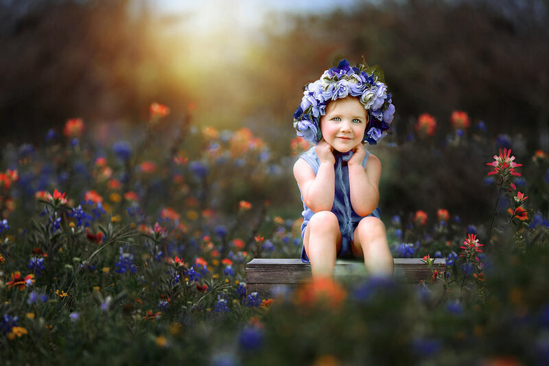 BEautifil blue eyed baby wearing a flower crown sitting on a filed of bluebonnets in Houston, Texas.