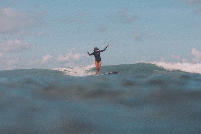 Woman surfing perfect waves at Santai Retreats in Indonesia