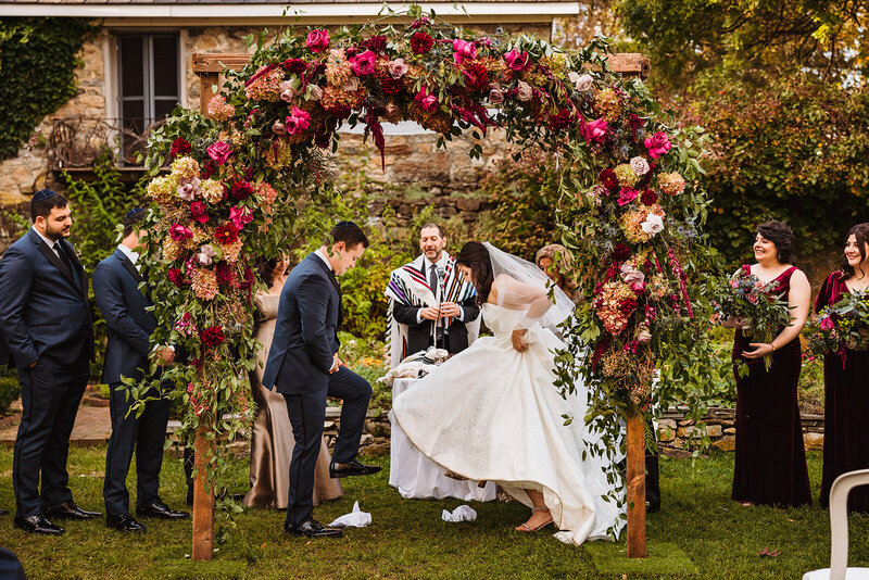 Beautifully decorated chuppah , bride and groom breaking glass