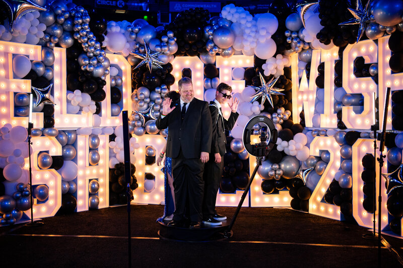 Guests posing on a 360 MISGIF photo booth platform surrounded by a glamorous balloon and marquee light backdrop at an upscale corporate event in Phoenix, Arizona